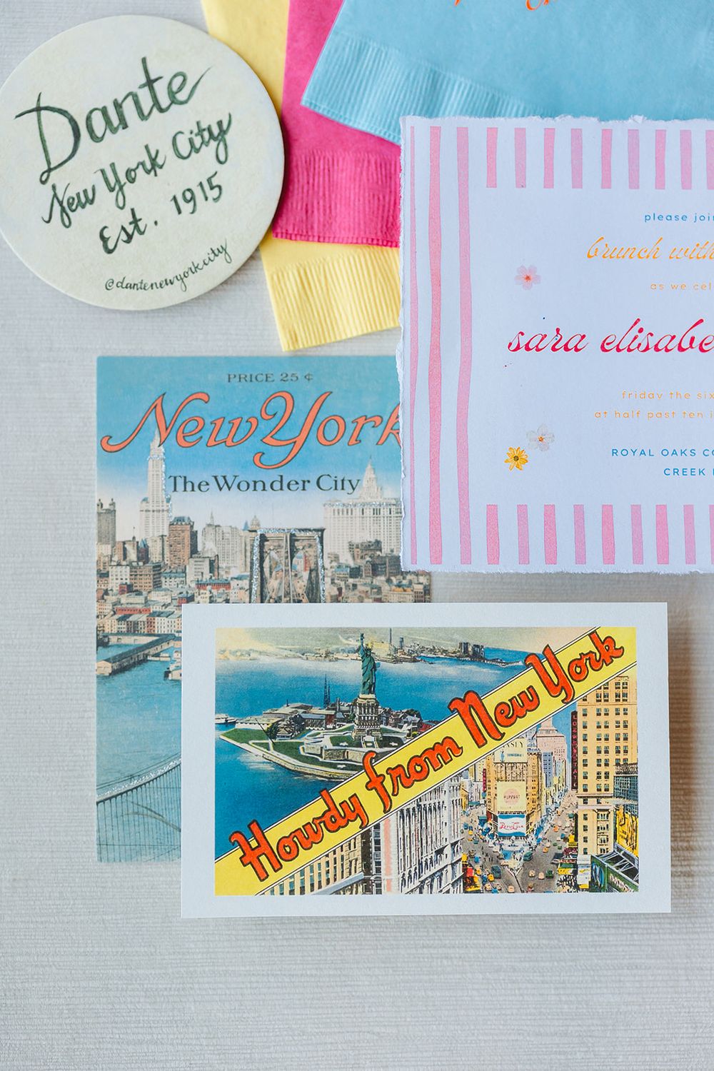 A collection of vintage-style New York City postcards and ephemera featuring city skylines and landmarks laid out on a table.