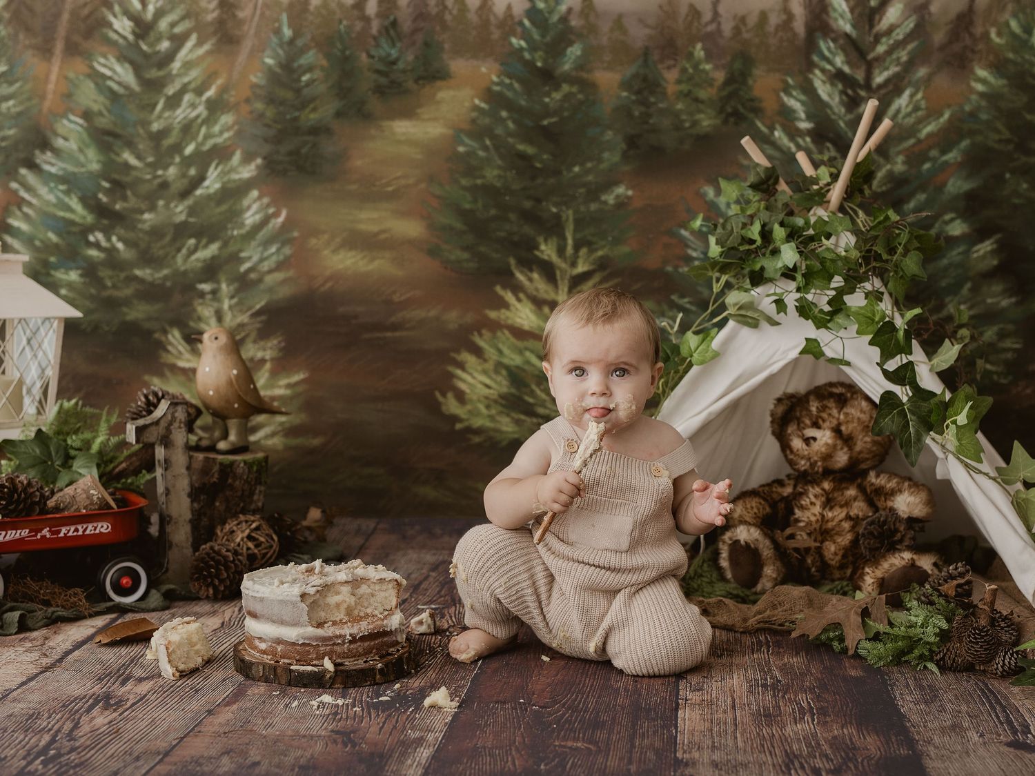 A rustic autumn cake smash setup with a white cake, lantern, dried flowers and fall decorations in warm brown tones.