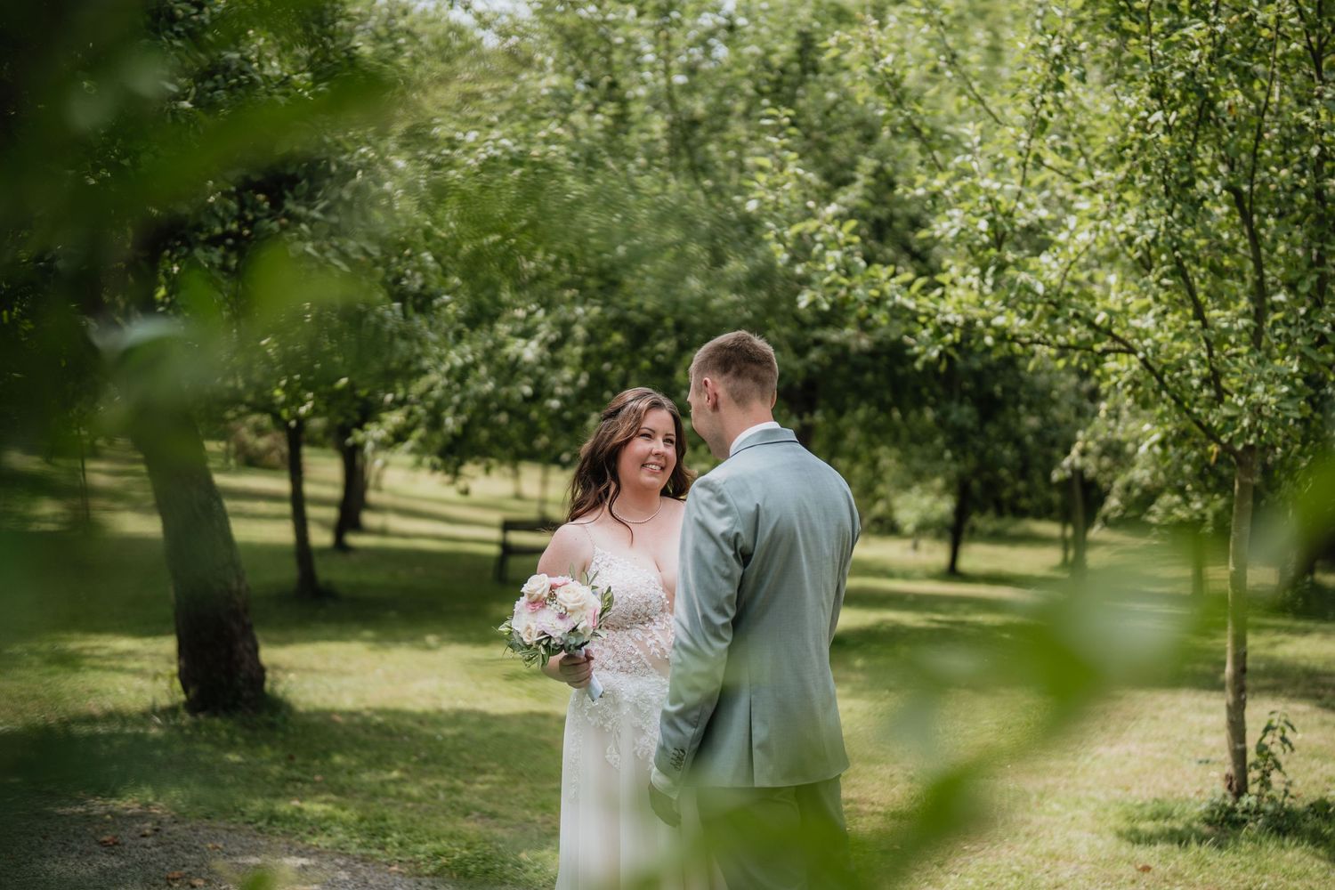 Couple sharing a tender moment together in a lush green garden setting.