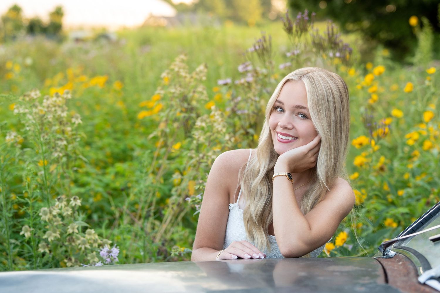 Someone lying in a vibrant yellow wildflower meadow on a sunny summer afternoon.