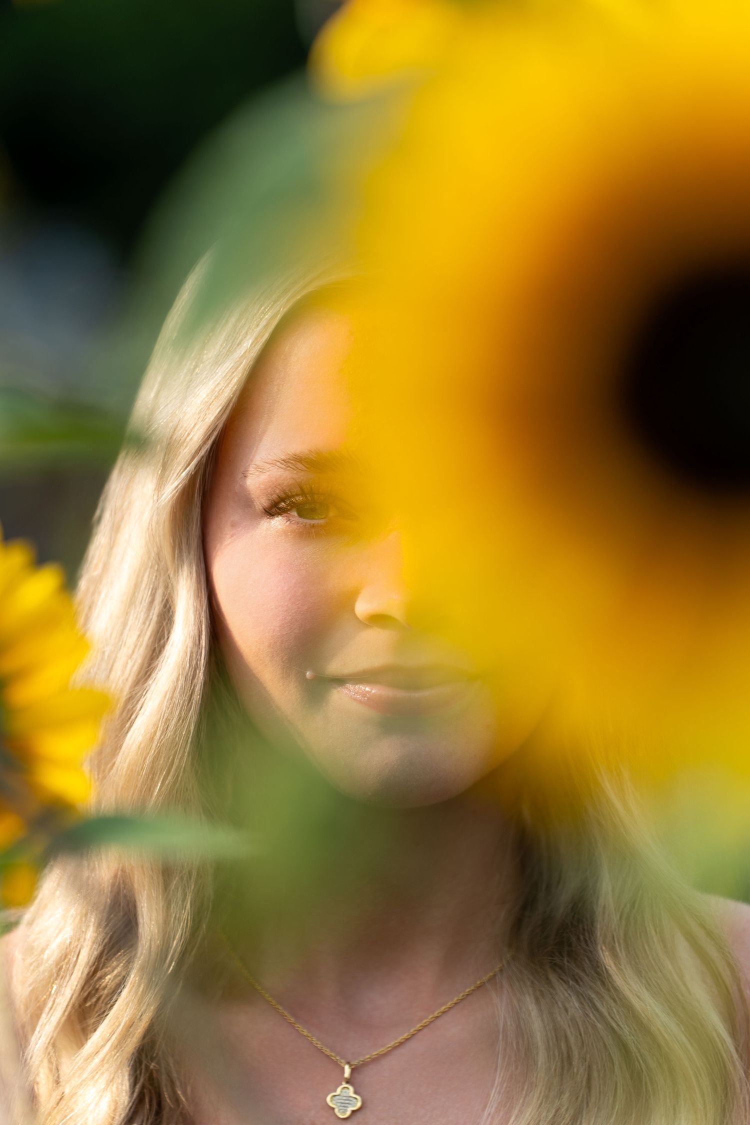 Yellow sunflowers frame a soft, dreamy portrait creating a warm summer aesthetic.