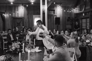 Dancing couples enjoy a joyful celebration on a dimly lit dance floor at an evening reception event.