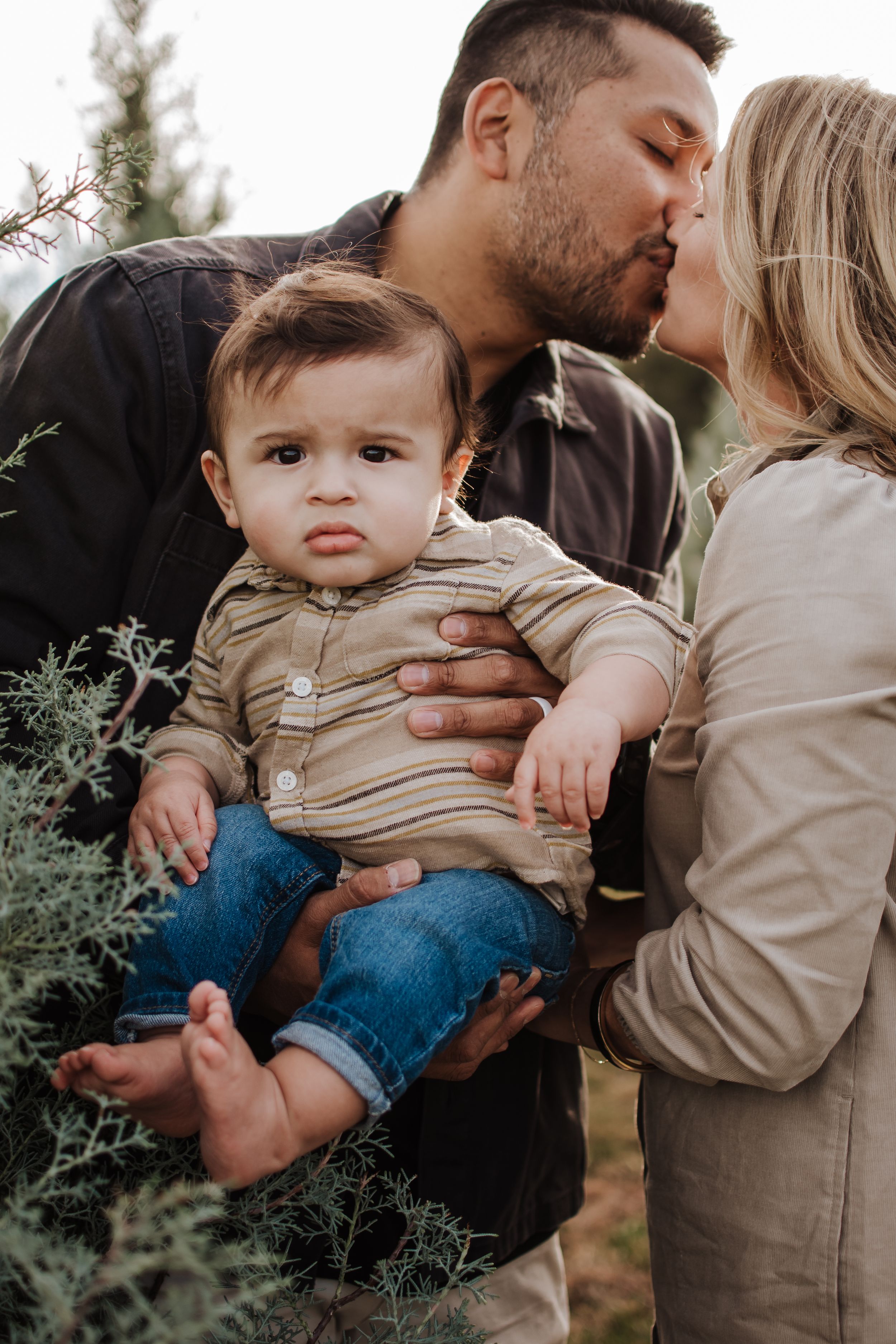 Holiday mini session with warm outfits and evergreen backdrop near Fort Worth