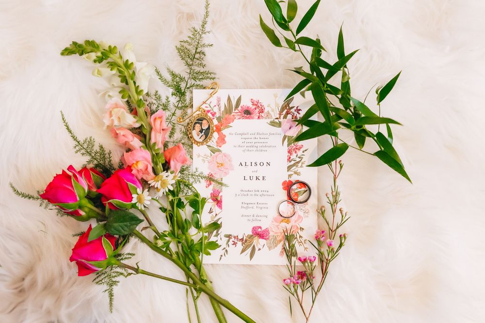 Delicate pink and green floral arrangements with invitation cards displayed on white background.