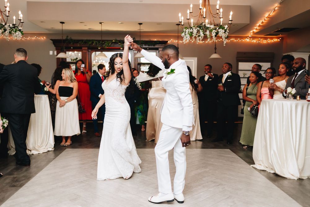 Couple dancing at their wedding reception under crystal chandeliers.