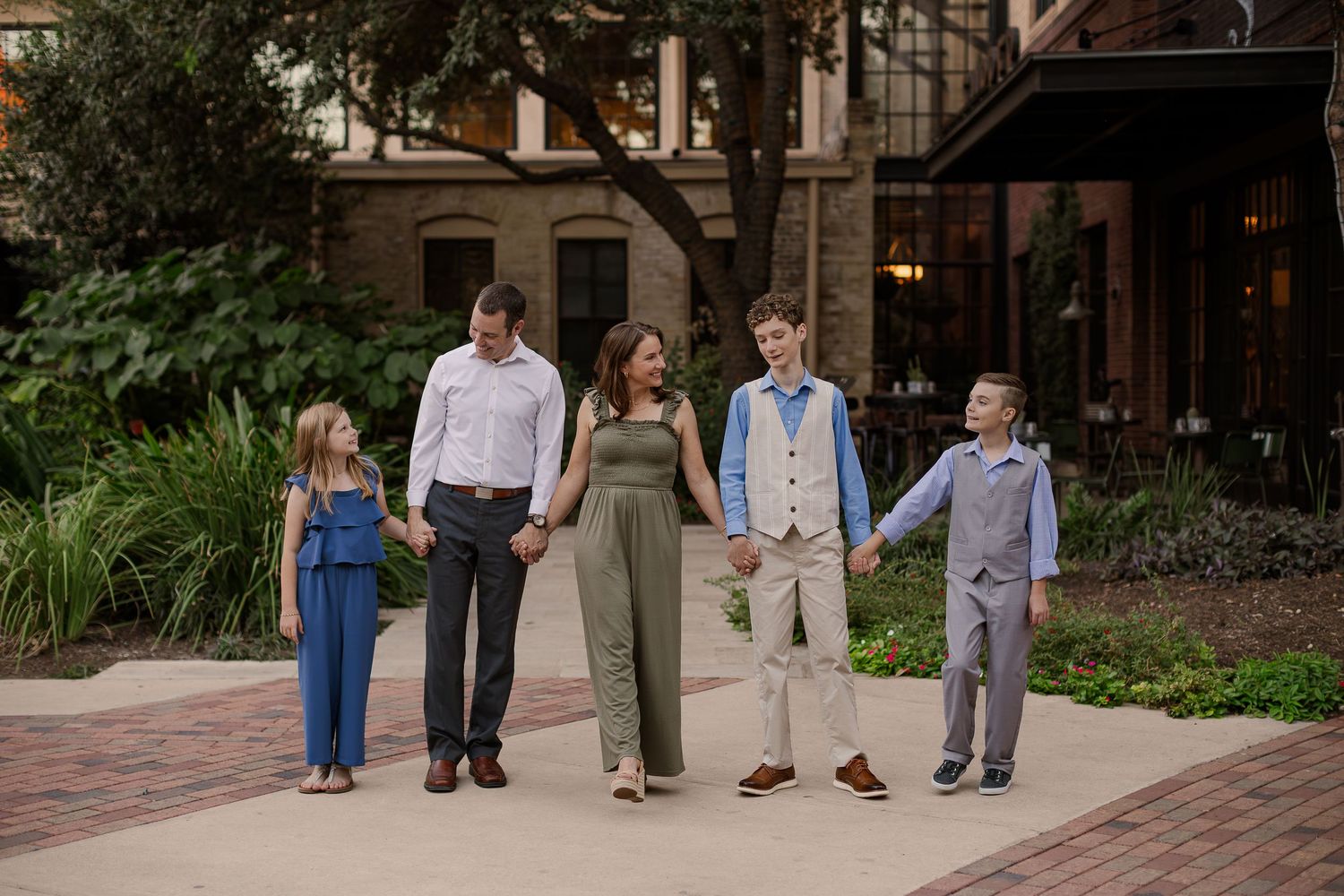 Family sitting on blanket together outdoors during golden hour sunset for autumn portrait session. San Antonio family Photographer