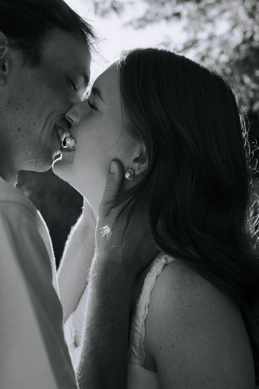 A romantic black and white photo sequence showing an intimate kiss between a couple.