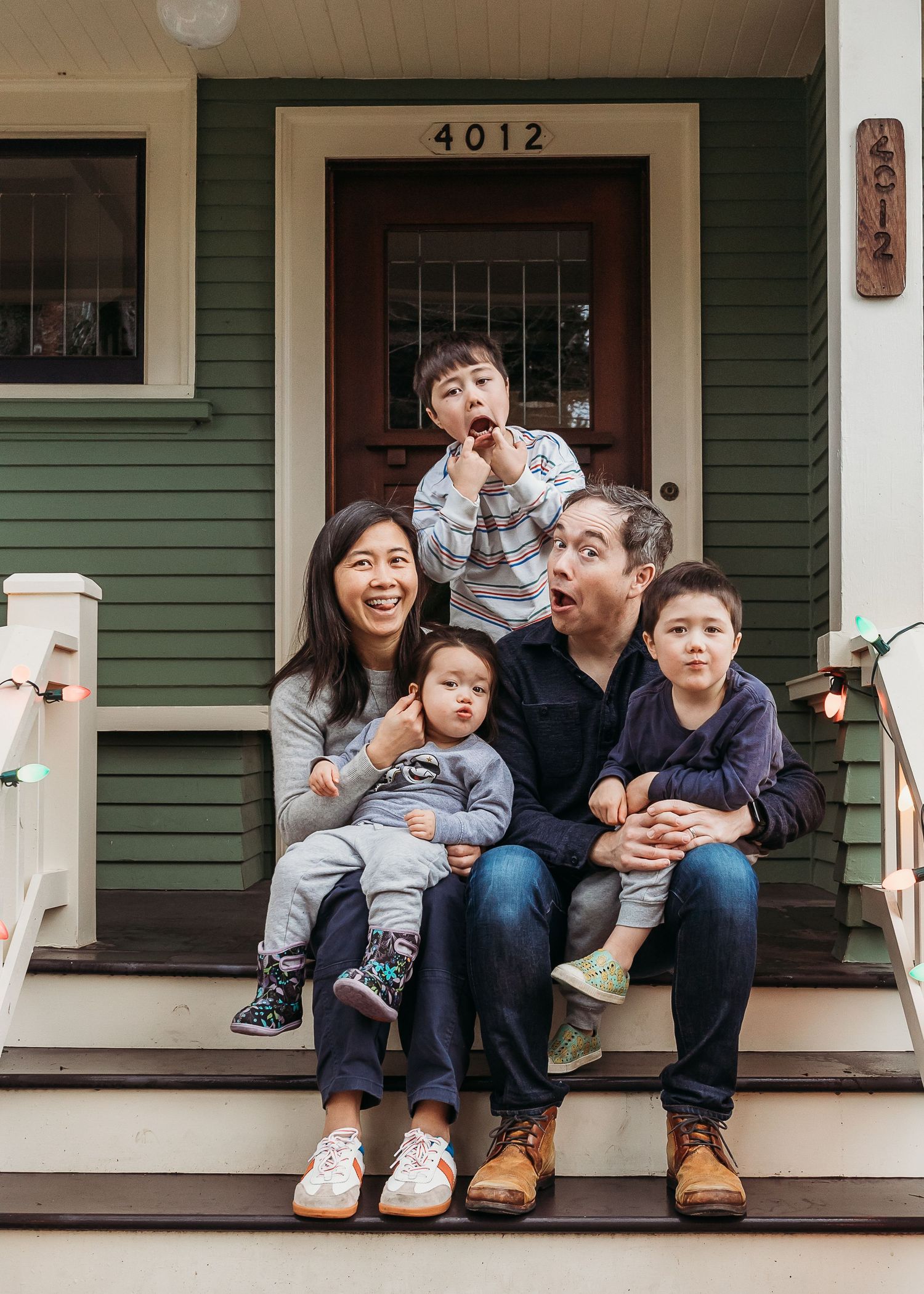 Four connected images show a family playfully laughing and interacting on a front porch of a green house.