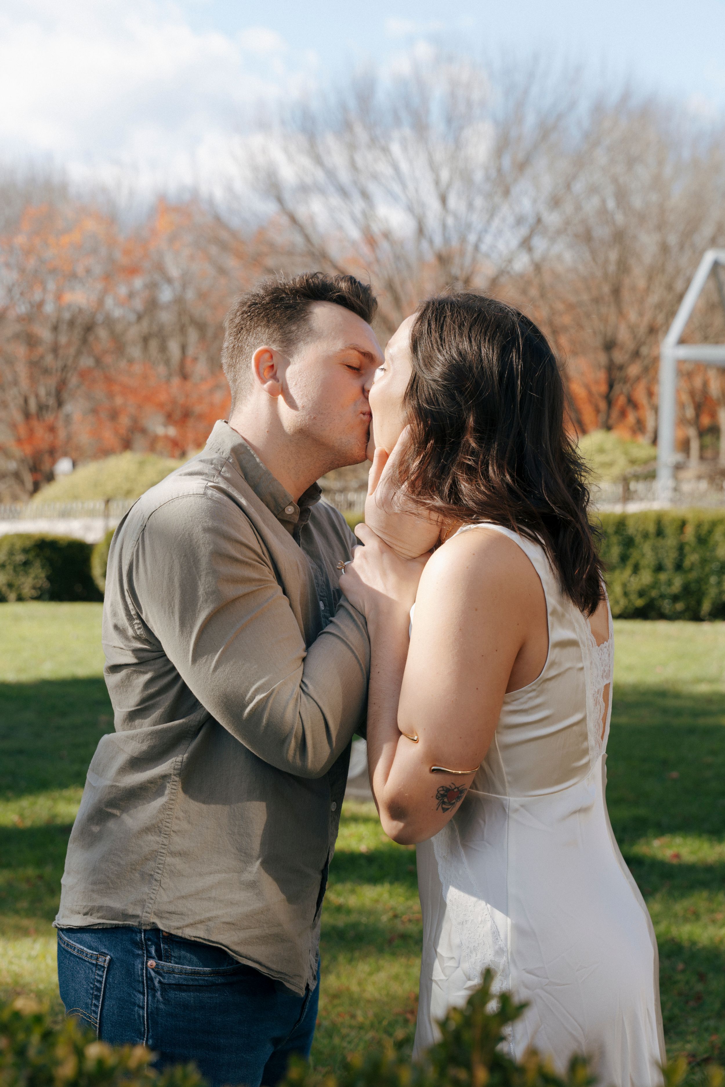 A romantic couple shares tender moments in a series of outdoor photos in a park during autumn.