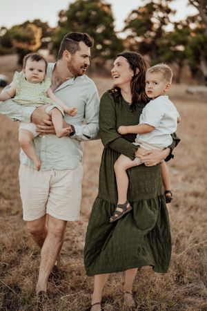 Family in coordinated neutral outfits having fun together in a natural outdoor setting.