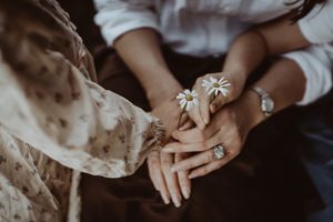 Close-up detail of hands touching during an intimate family moment.
