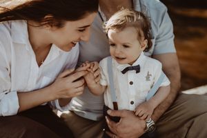 A tender moment between parent and child in formal attire with a bow tie.