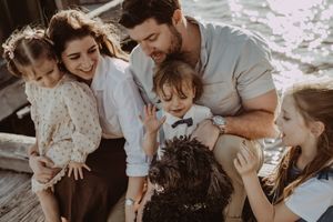 Family sharing joyful moments together on a beach at sunset.