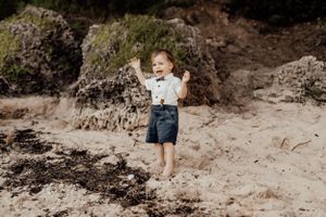 Children playing and running on a sandy beach trail during a sunny day.