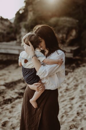 Artistic black and white portrait of parent and child embracing outdoors.