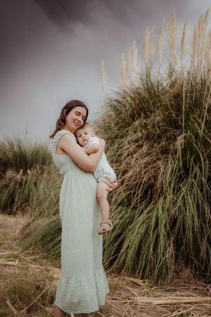A tender moment captured between mother and child against swaying pampas grass.