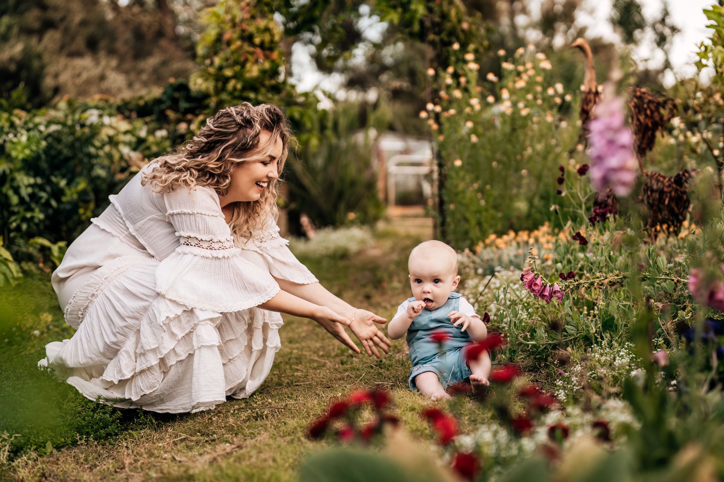 Family sharing intimate moments together in a garden with blooming flowers.