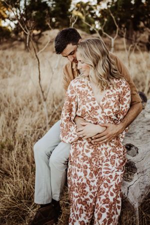 Intimate moment captured between couple on rocky terrain during golden hour photography session.