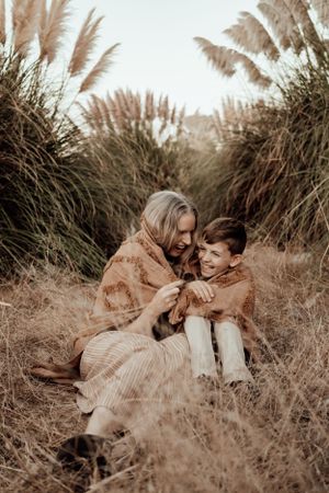 Intimate portrait session in field with tall grass and warm sunset lighting.