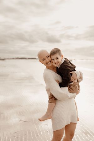Joyful embrace captured on a scenic beach during golden hour.