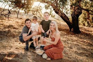 Group relaxing under a tree during golden hour in a scenic outdoor location.