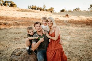 Family enjoying a tender moment together at sunset in a natural outdoor setting.
