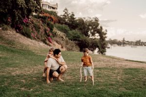 Natural seaside photoshoot with playful interactions on grassy slopes.