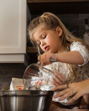 Pouring ingredients into a mixing bowl during a cozy baking session.