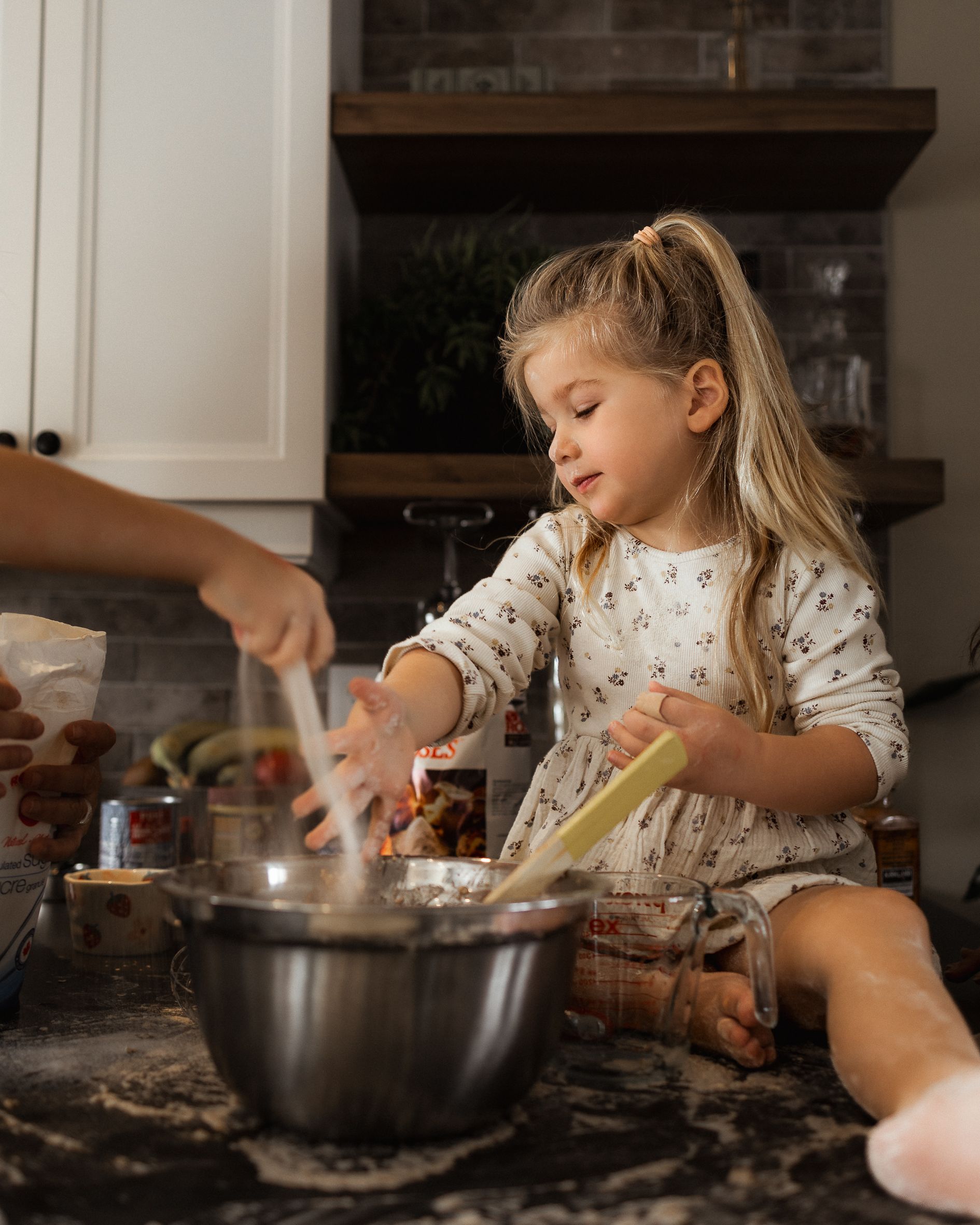 Making cookies in the kitchen with flour scattered on the counter.