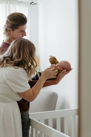A tender family moment in a nursery as new parents cradle their newborn.