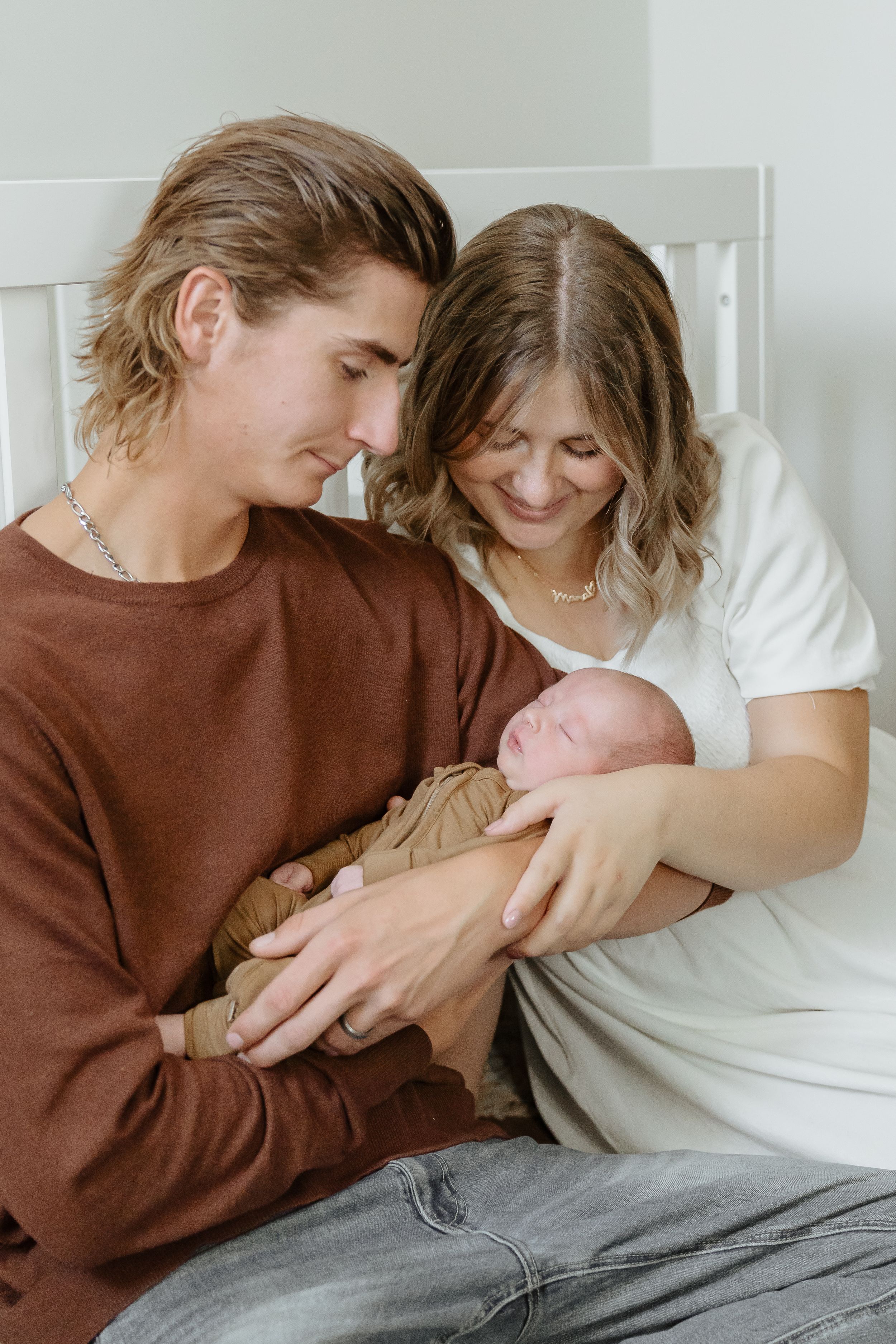 New parents sharing an intimate moment with their newborn baby at home.