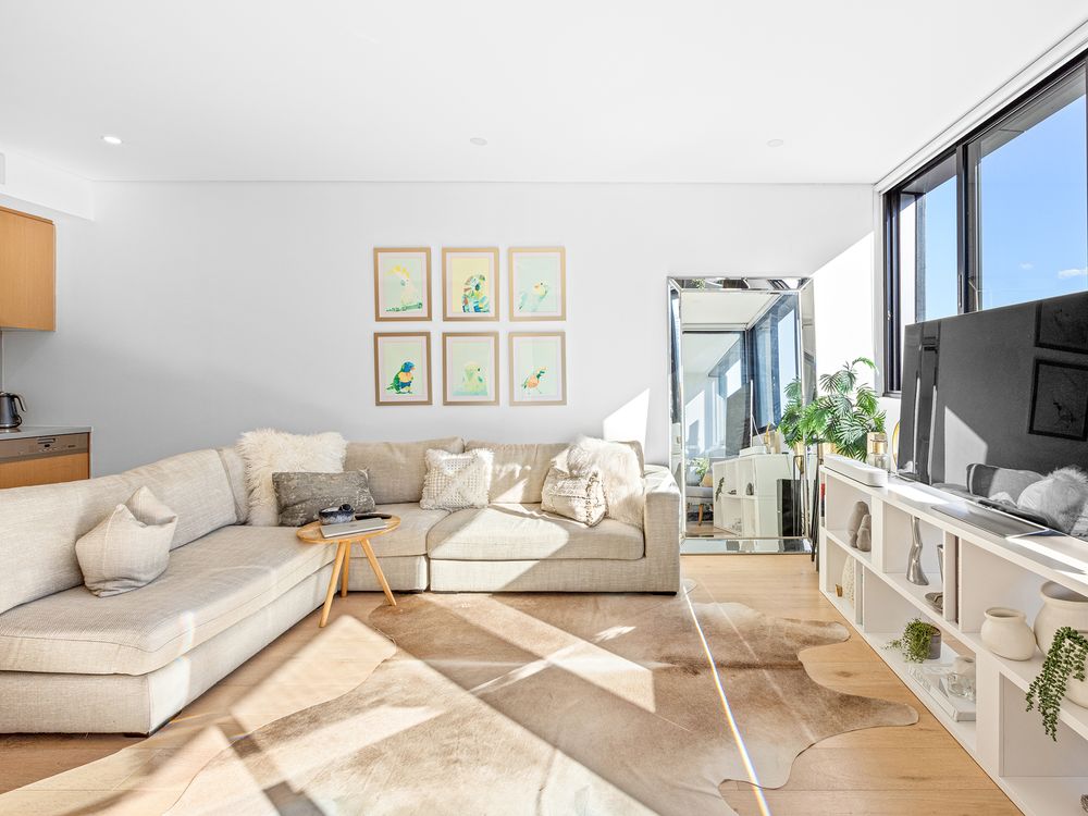 living room with white sofa and sun streaming through the windows