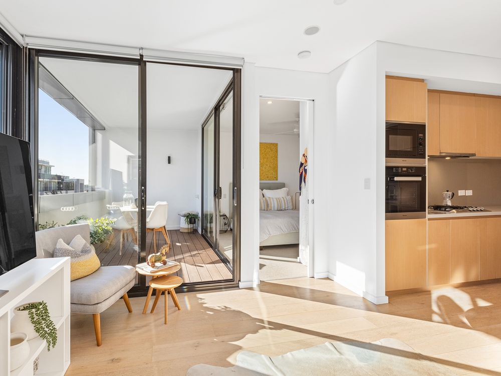 open plan living with balcony and bedroom in background and kitchen in foreground