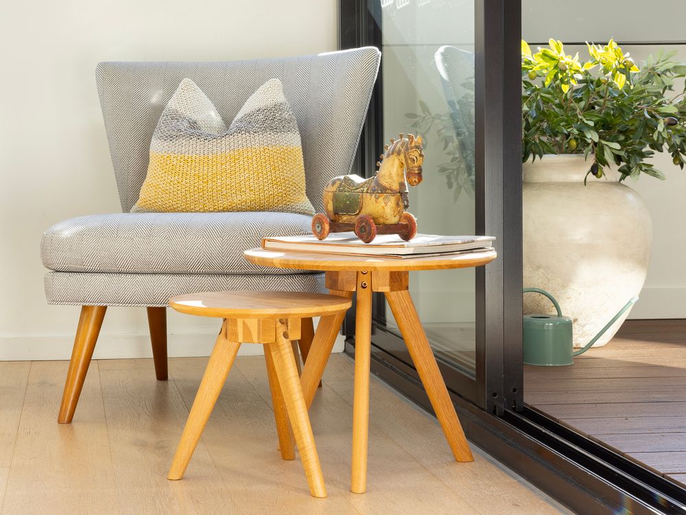 grey chair with wooden horse on small coffee table