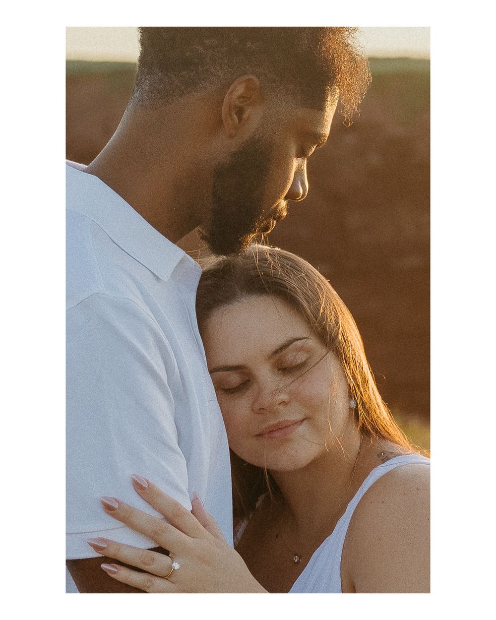 A romantic couple shares an intimate moment in golden sunlight during a photoshoot.