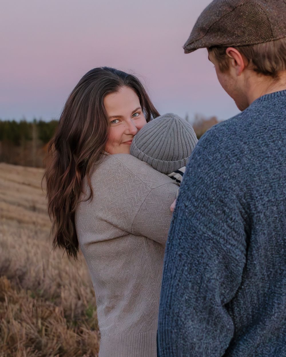 A sweet family moment captured at sunset in a rustic outdoor setting.