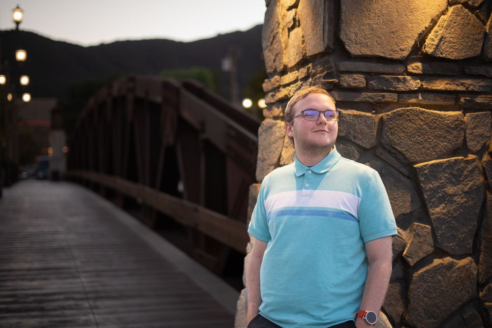 A warm evening scene with someone seated against a stone wall backdrop.