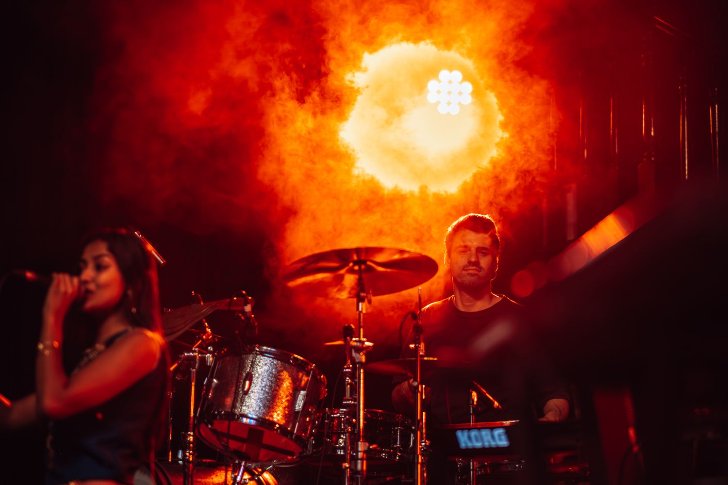Band performs on stage with dramatic orange lighting during evening concert taken by Melbourne concert and event photographer.
