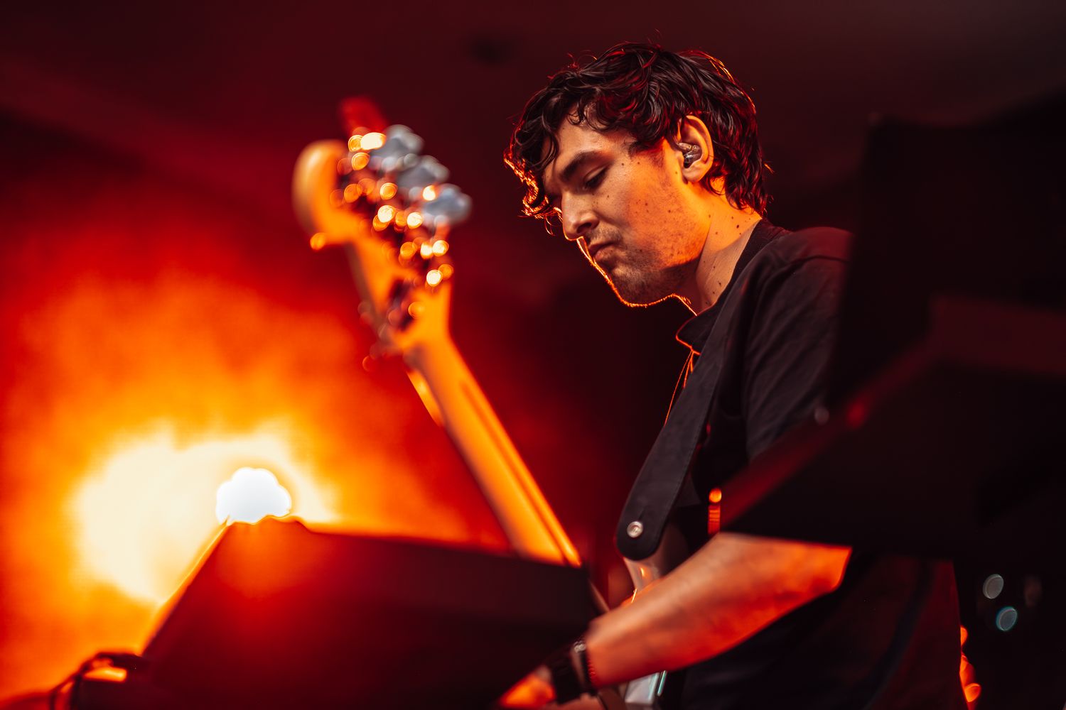 Band performs on stage with dramatic orange lighting during evening concert taken by Melbourne concert and event photographer.
