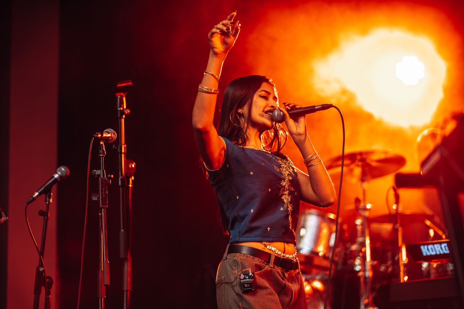 Band performs on stage with dramatic orange lighting during evening concert taken by Melbourne concert and event photographer.