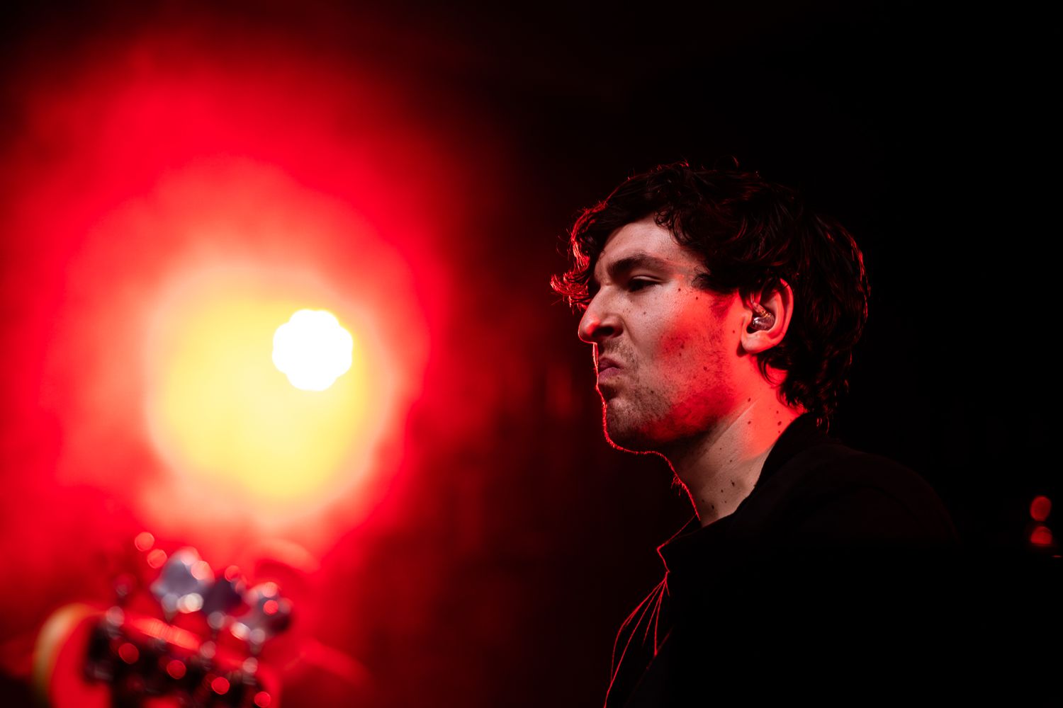 Band performs on stage with dramatic orange lighting during evening concert taken by Melbourne concert and event photographer.