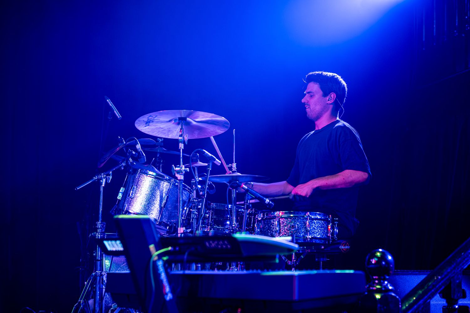Band performs on stage with dramatic blue lighting during evening concert taken by Melbourne concert and event photographer.