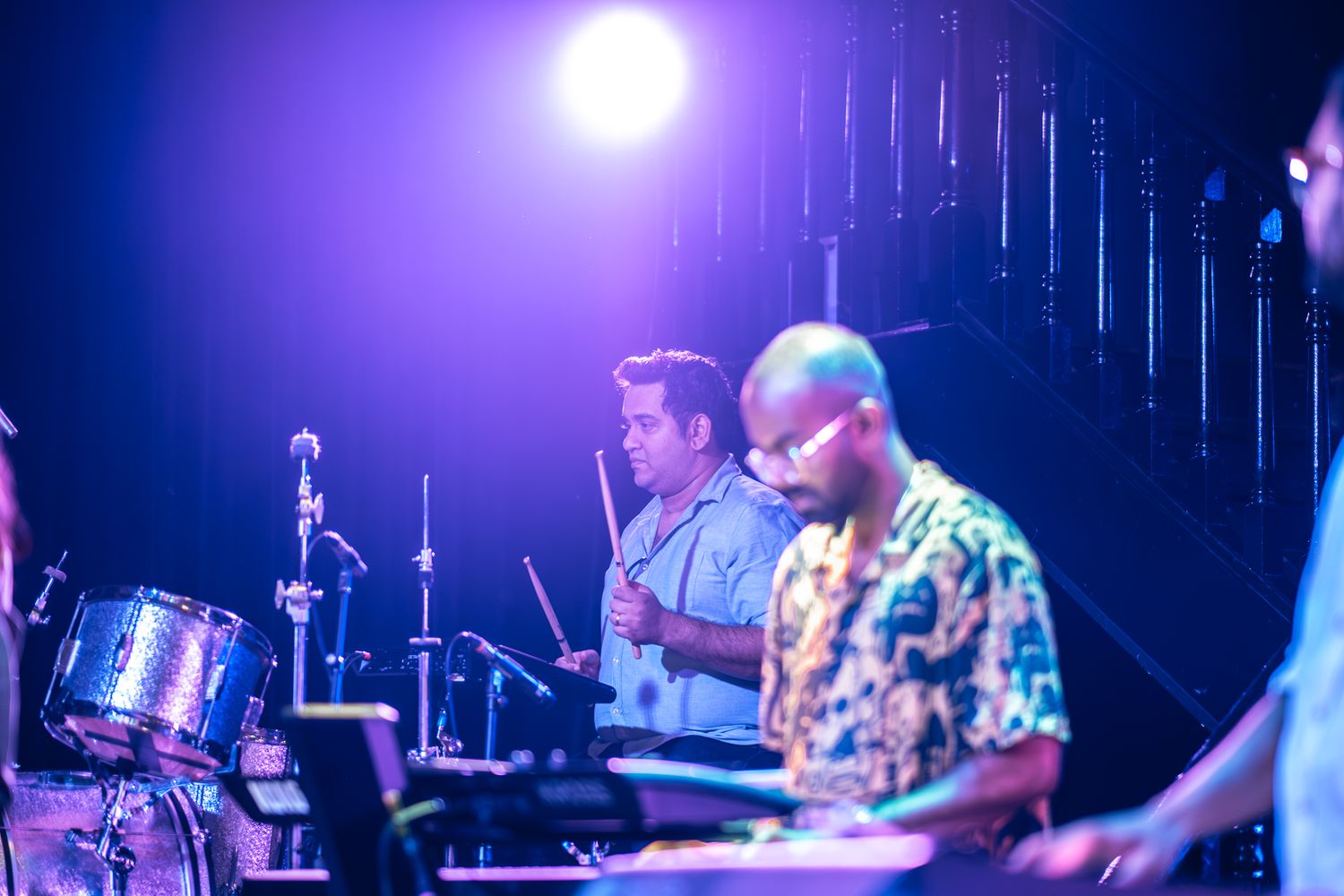 Band performs on stage with dramatic blue lighting during evening concert taken by Melbourne concert and event photographer.