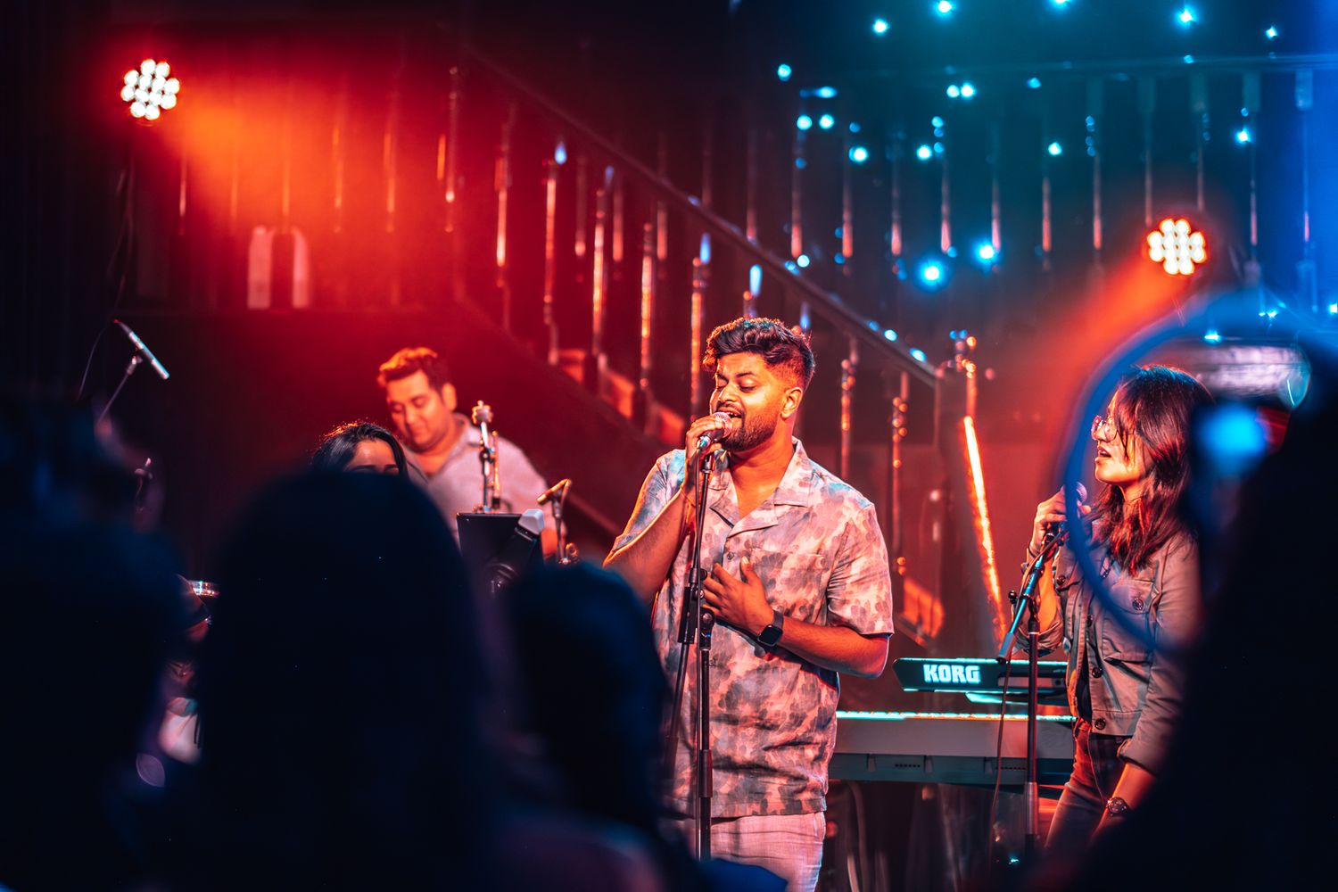 Band performs on stage with colorful rainbow lighting during evening concert taken by Melbourne concert and event photographer.
