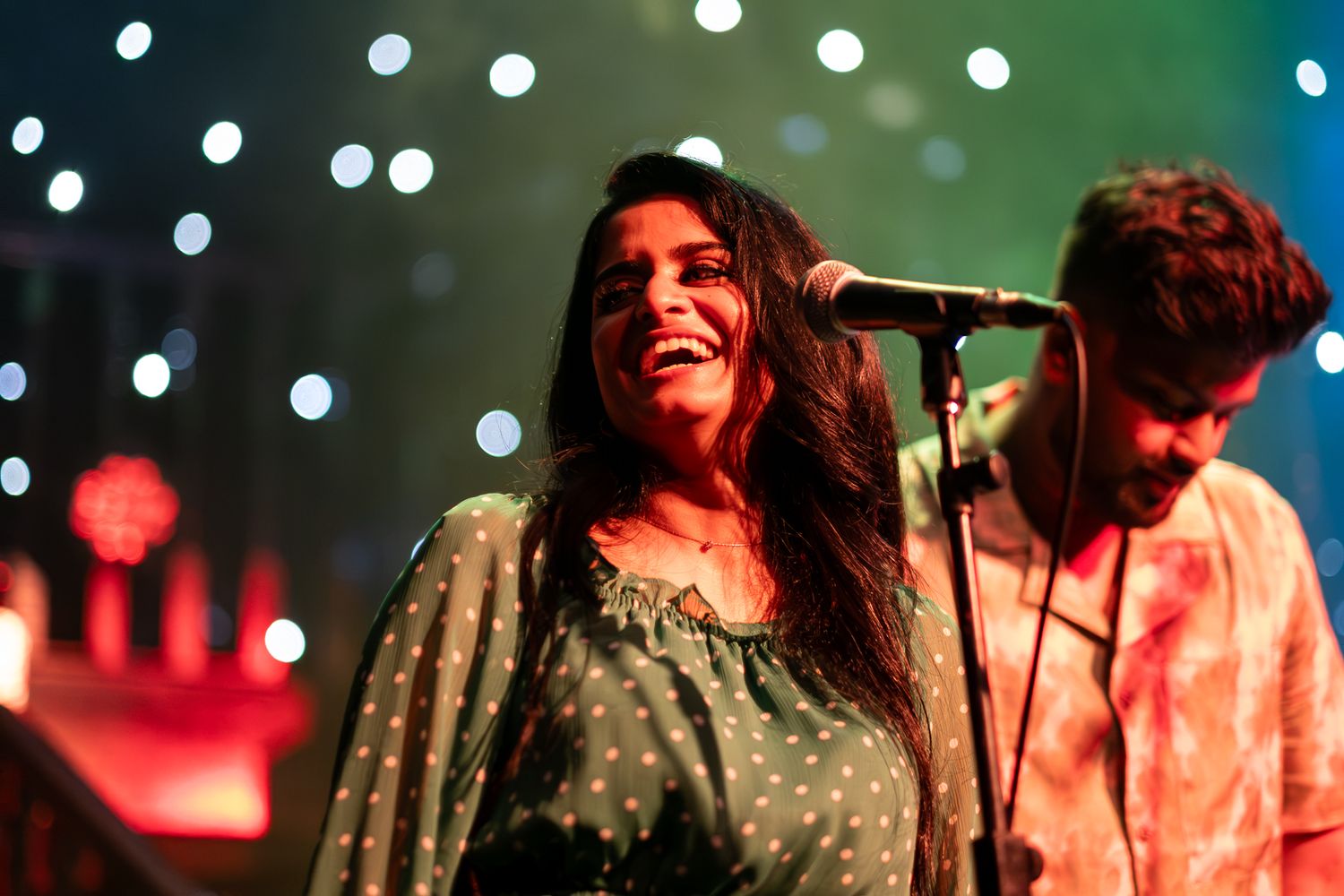 Singer performing on stage with sparkling lights in background taken by Melbourne concert and event photographer.
