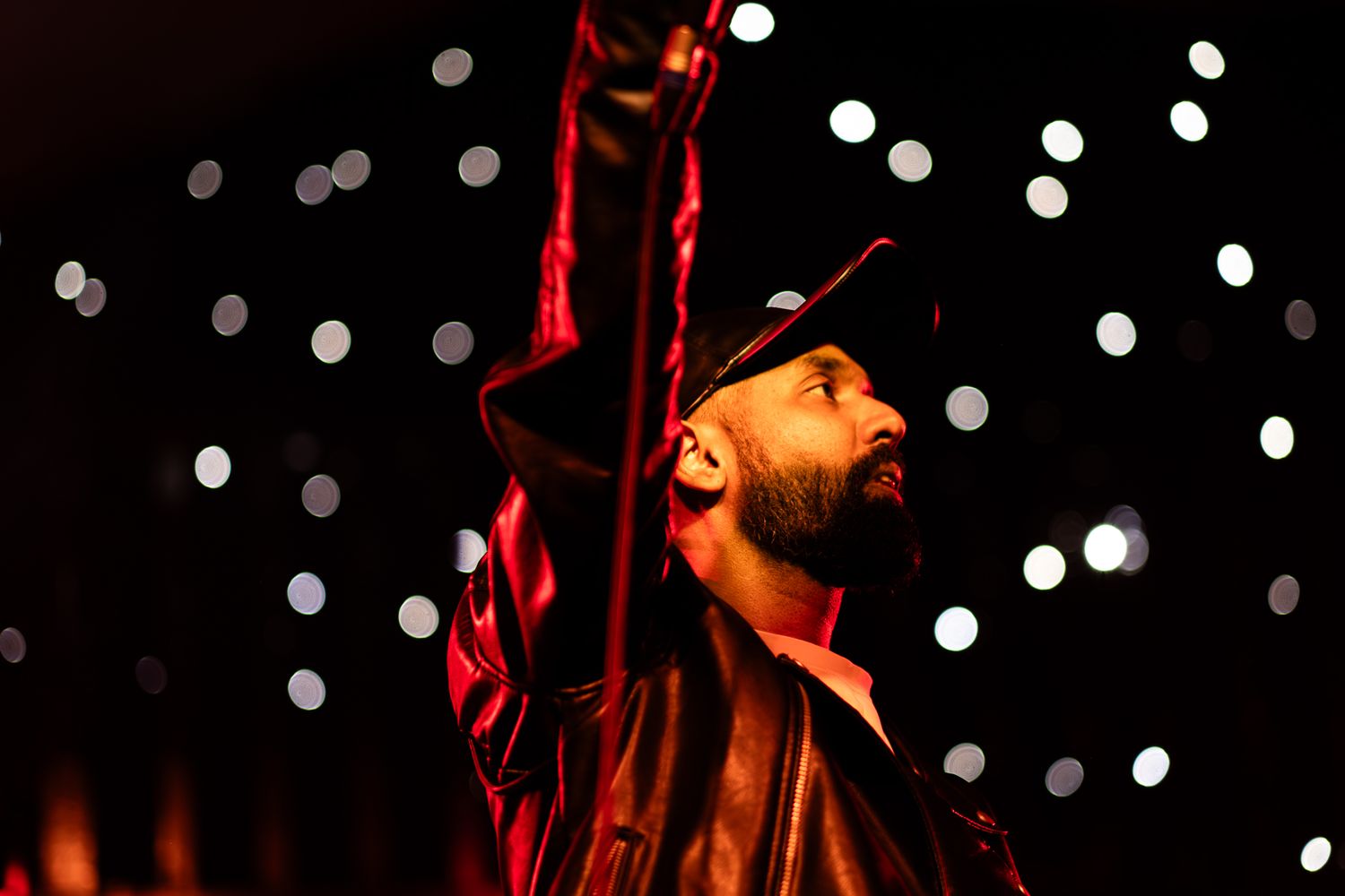 Dramatic concert performance with singer illuminated by bright orange stage lighting taken by Melbourne concert and event phorographer.