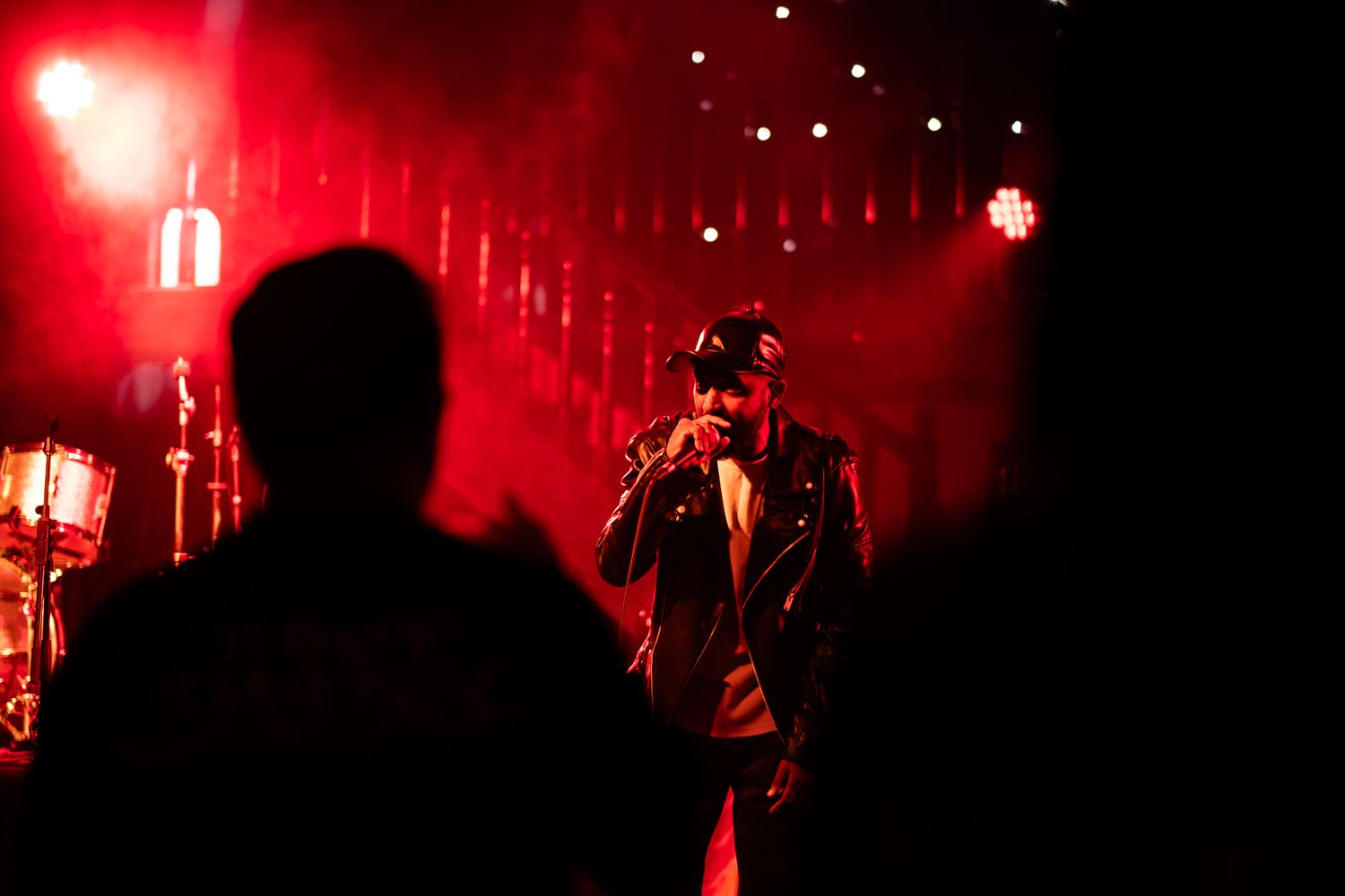 Dramatic concert performance with singer illuminated by bright orange stage lighting taken by Melbourne concert and event phorographer.