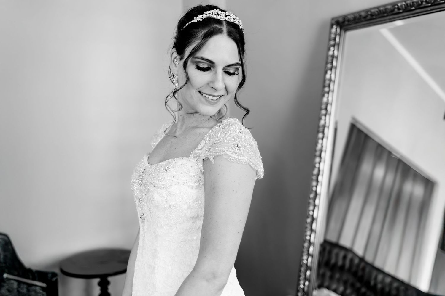 An elegant black and white portrait of a bride in a lace wedding gown.