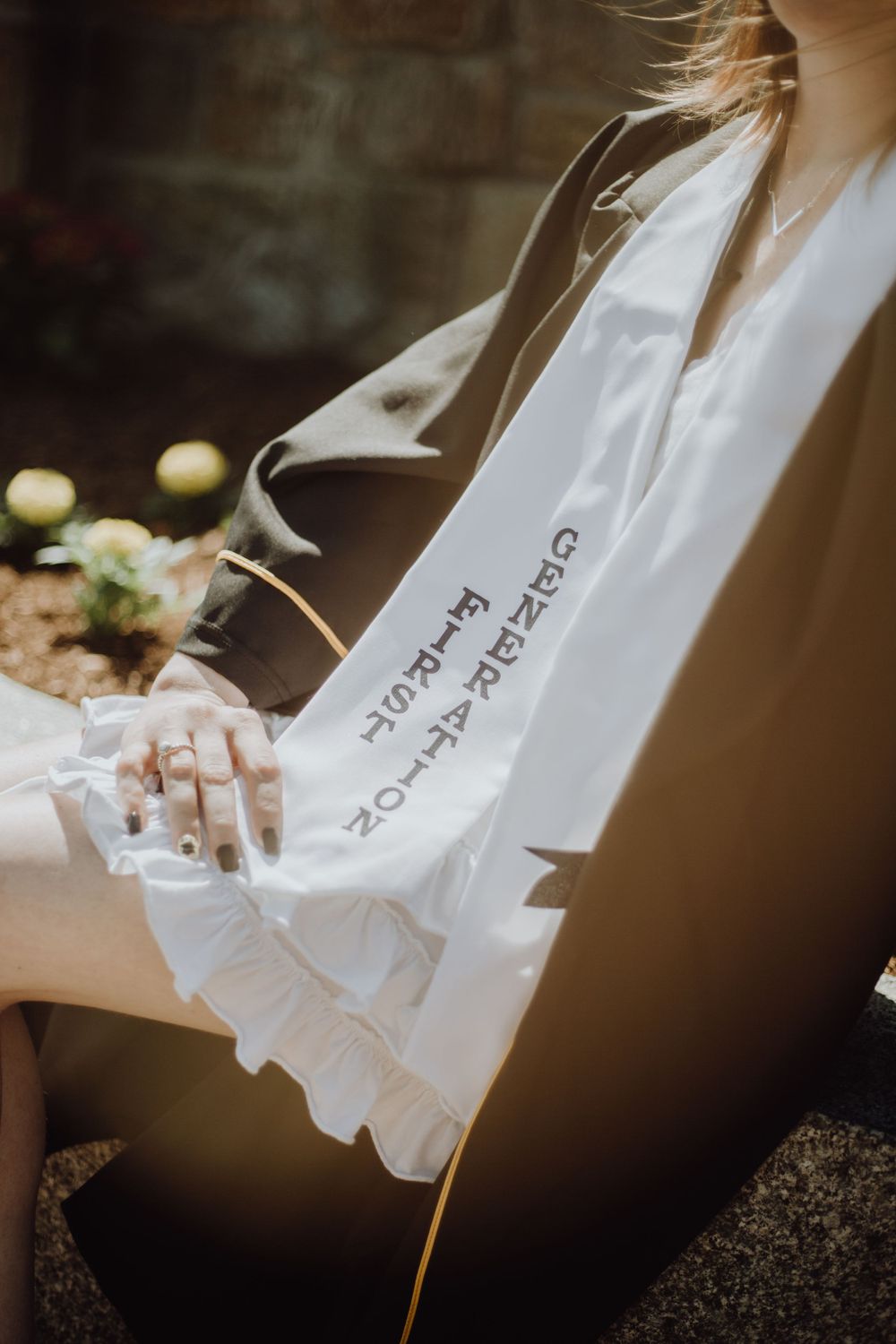 Close-up detail of graduation stole and gown in soft natural lighting.