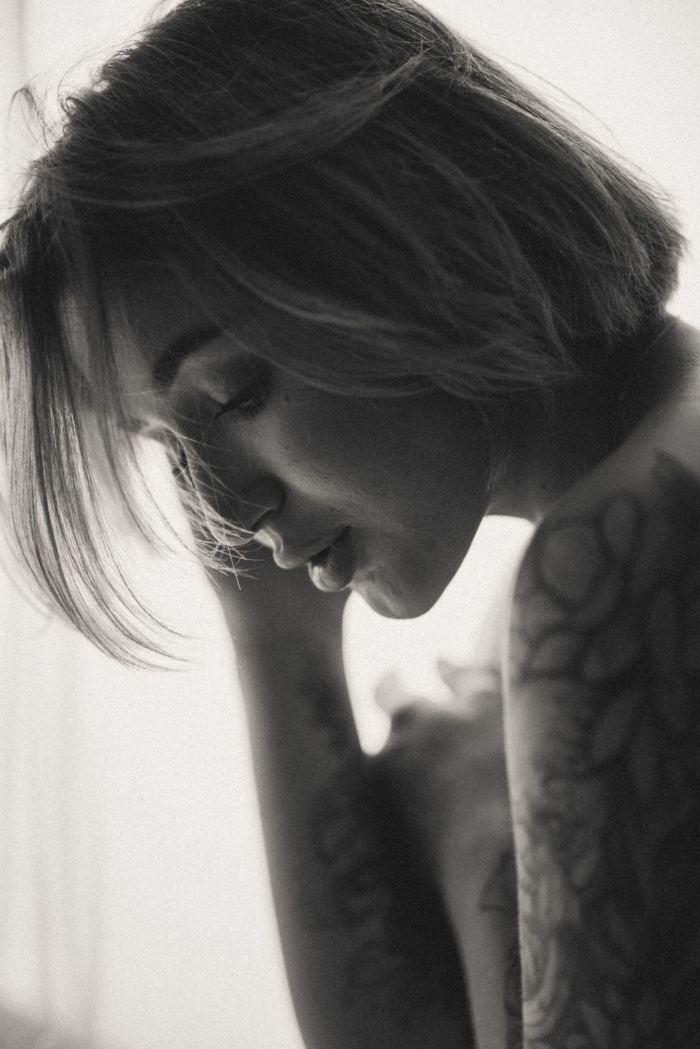 Dramatic black and white side profile portrait with soft lighting.